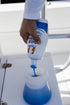 Person pouring 1st due boat soap into a spray jar.
