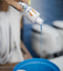 Person pouring 1st due boat soap into a blue bucket to wash down the boat.