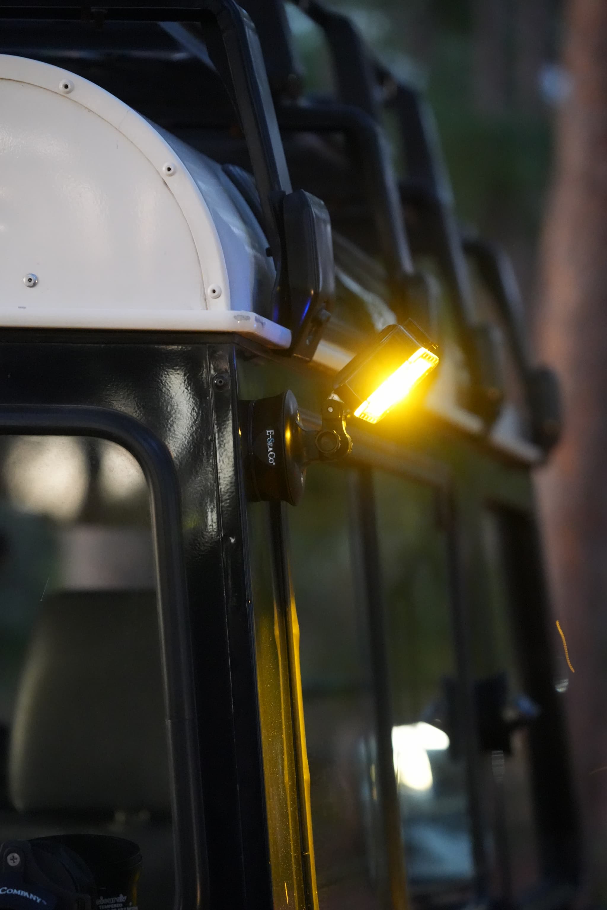 E-Sea Light Suction Mounted to an overlanding land rover defender, illuminating a camp site. 